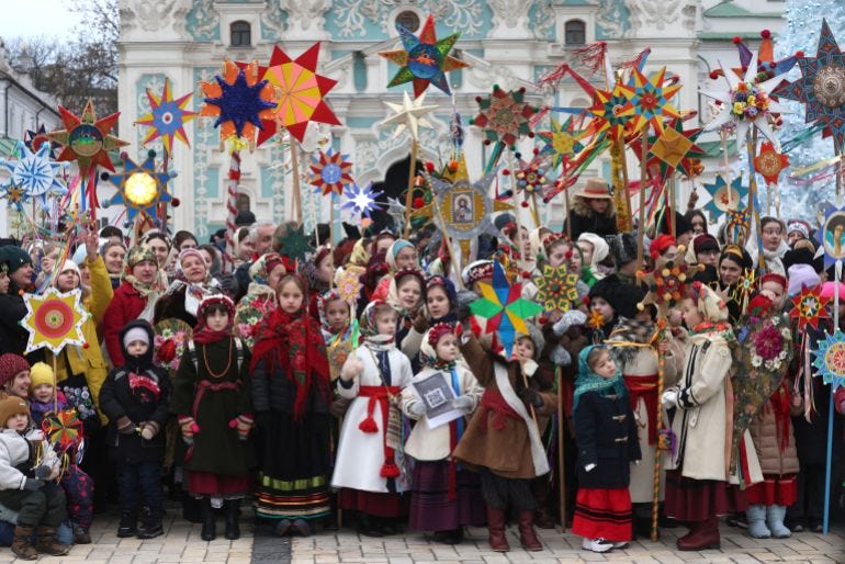 Ukrainians wearing traditional clothes take part in a Christmas procession at the Sofiivska Square in Kyiv, on December 25, 2024. [Anatolii STEPANOV / AFP]