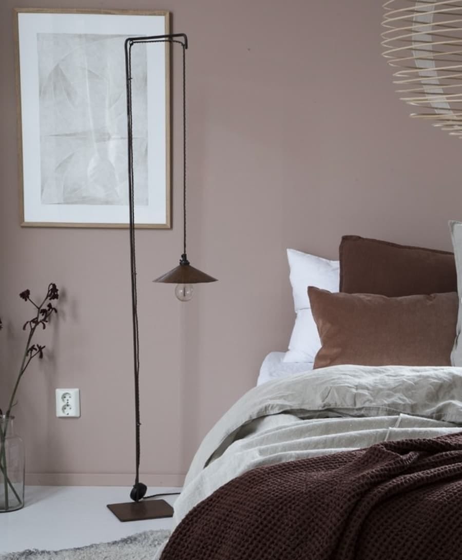 muted, warm neutral bedroom with cosy accessories on the bed