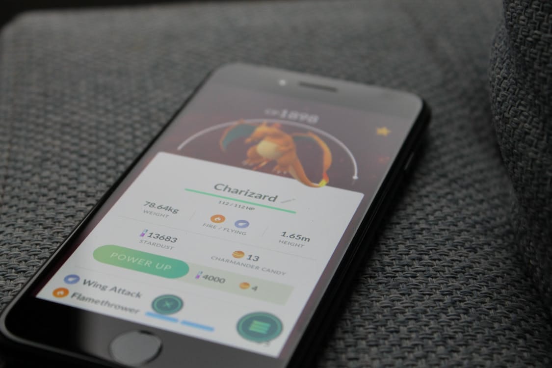 Free Turned-on Iphone Displaying Pokemon Go Charizard Application Stock Photo