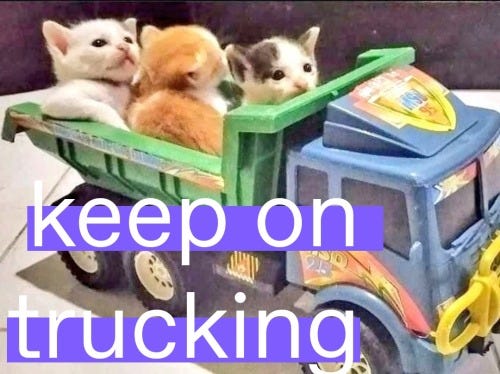 A toy dump truck appearing to transport several very young kittens, who look very okay with this situation. They are overlayed with the text KEEP ON TRUCKING