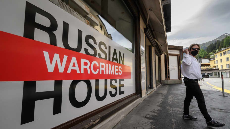 A security personnel reacts next to the entrance of Russia House, transformed into "Russian Warcrimes House", showing a picture exhibition documenting alleged war crimes committed by Russian troops in Ukraine, organised by The Victor Pinchuk Foundation, during the World Economic Forum (WEF) annual meeting in Davos on May 22, 2022.