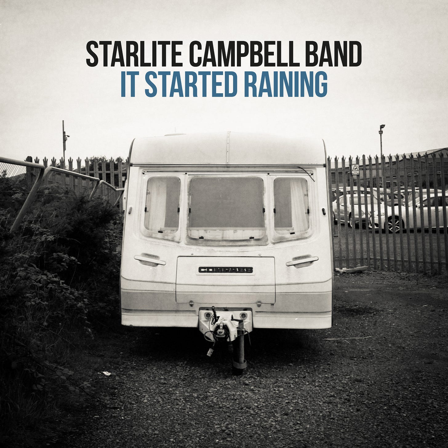 Single cover for 'It Started Raining' by Phil Kneen. It is a bleak caravan in a car park.