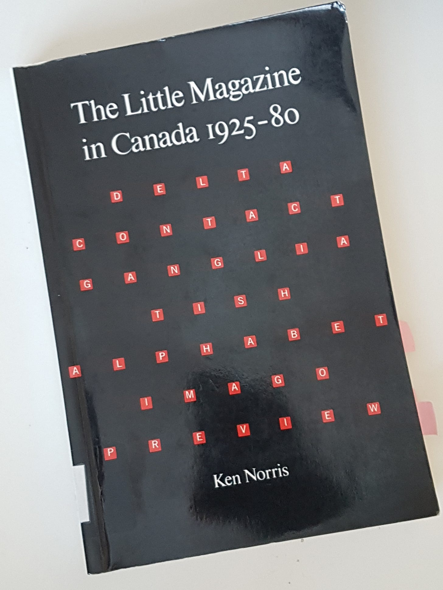 Photograph of the book, The Little Magazine in Canada, with a black cover and blocks of red text spelling out the names of magazines