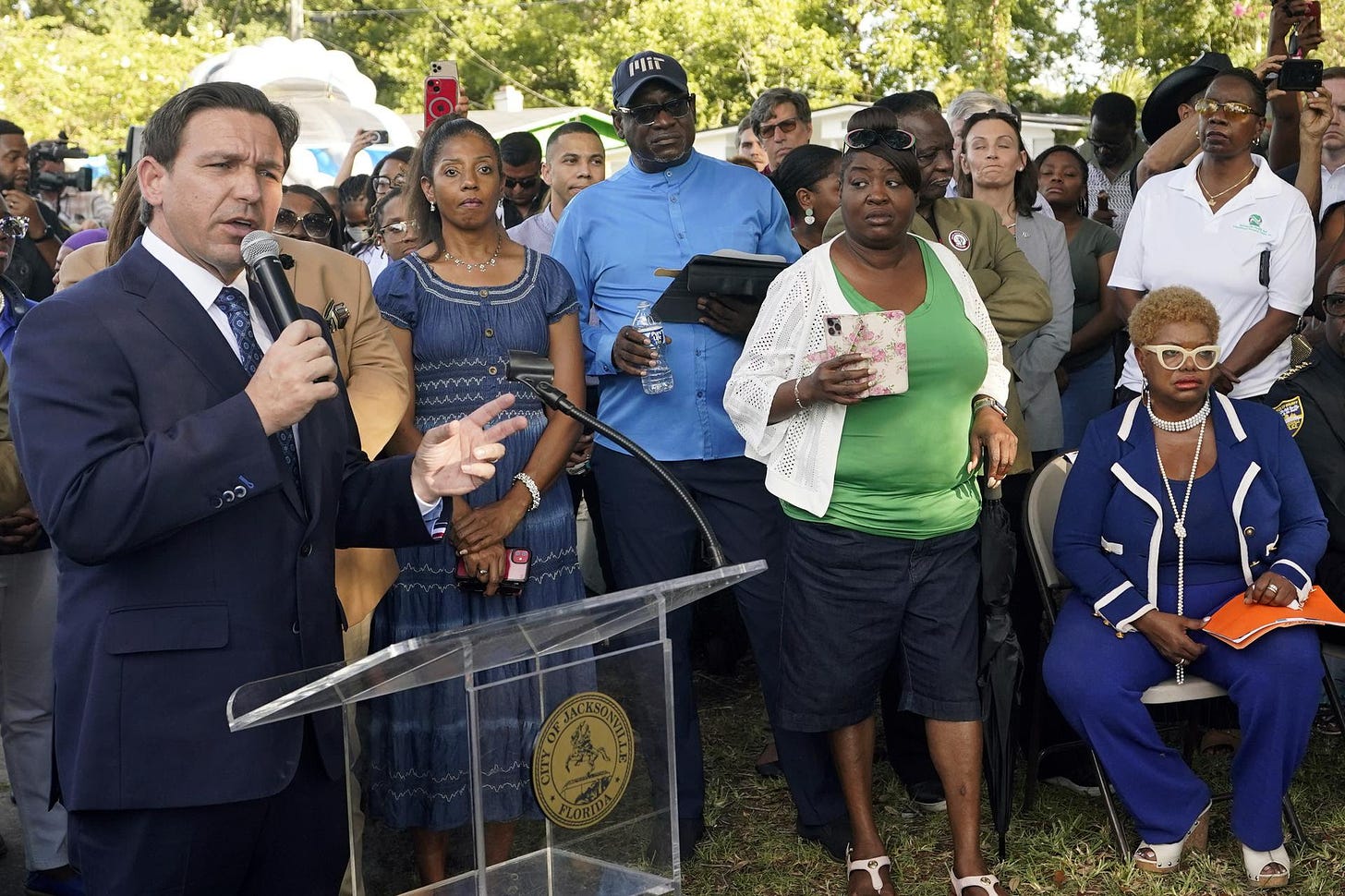Florida Gov. Ron DeSantis, left, speaks at a prayer vigil for the victims of a mass shooting, Jacksonville, Fla.