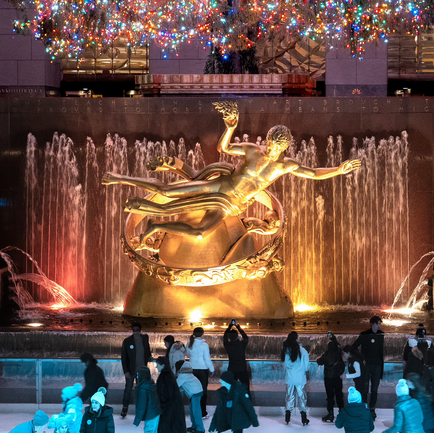 Statue of Prometheus at Rockefeller Center beneath a Christmas tree and overlooking a skating rink.