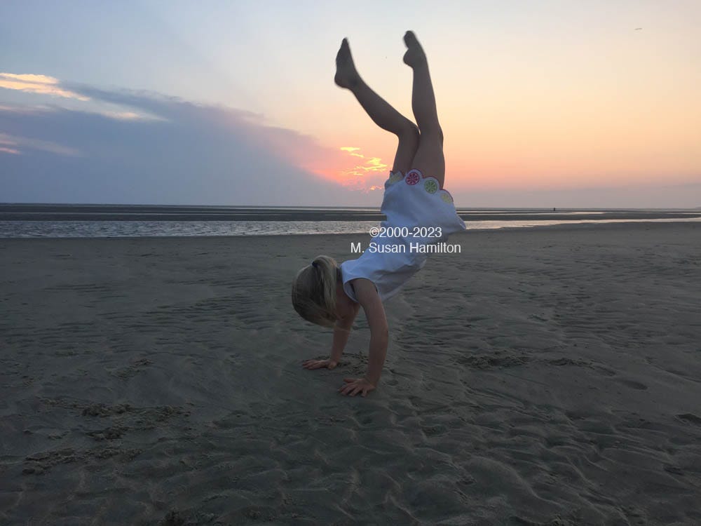 Photo of girl doing cartwheels at the beach