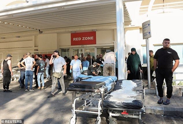 Doctors and bystanders await the arrival of victims injured by exploding pagers