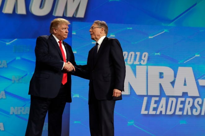 In this file photo, President Donald Trump shakes hands with NRA executive vice president and CEO Wayne LaPierre, has he arrives to speak to the annual meeting of the National Rifle Association, Friday, April 26, 2019, in Indianapolis.