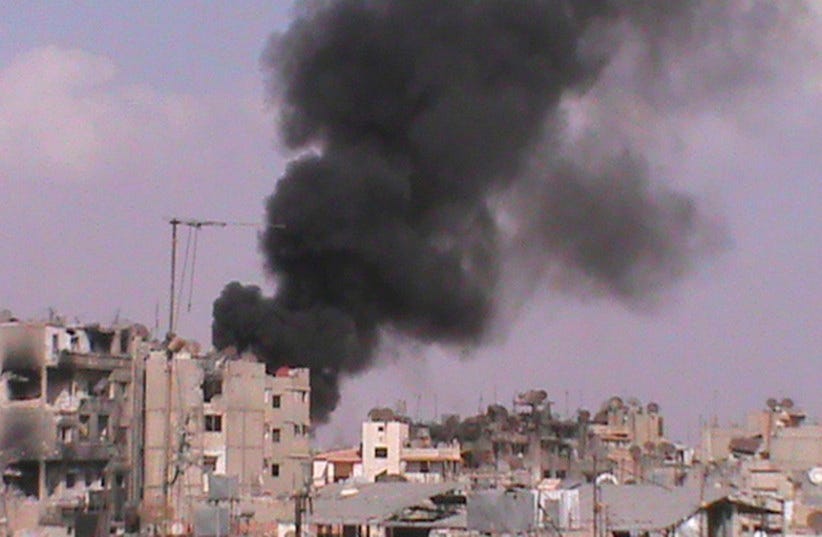 Smoke rises after what activists said was shelling by forces loyal to Syria's President Bashar al-Assad in Homs October 6, 2012. (photo credit: REUTERS/SHAAM NEWS NETWORK/HANDOUT)