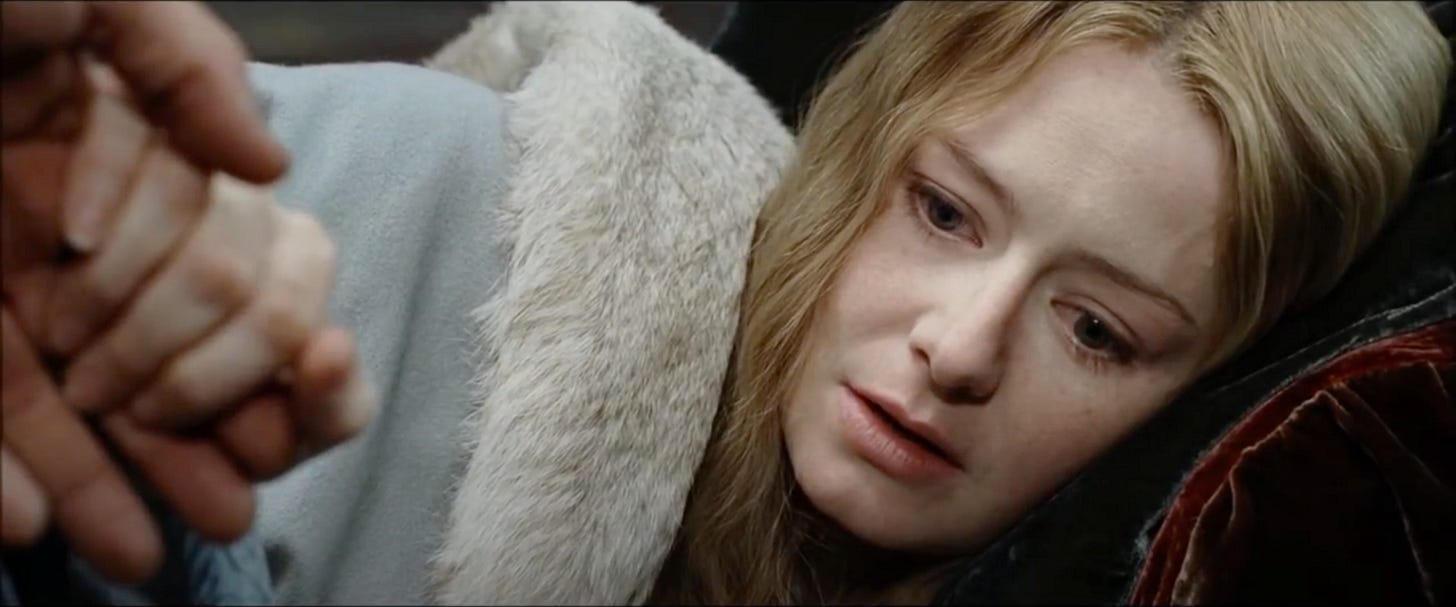 Eowyn clutches Aragorn's hand, recently awoken fro her dream of the Great Wave. she is staring into nothing, wearing a pale blue cloack trimmed with white fur.