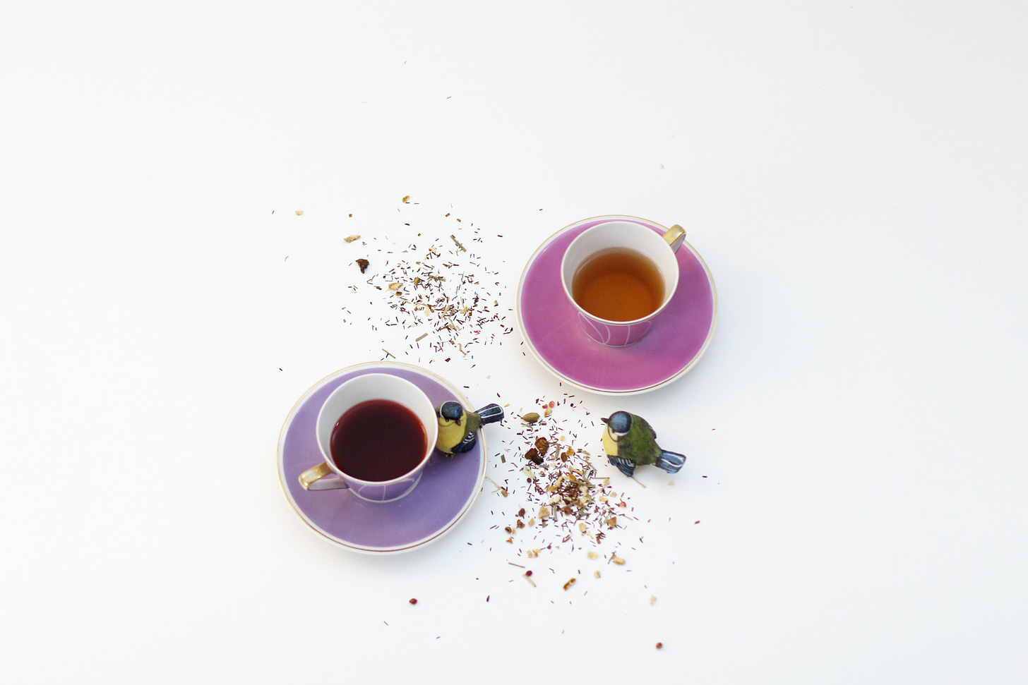 Two cups of tea with two bird statues by Katrin Hauf via Unsplash.