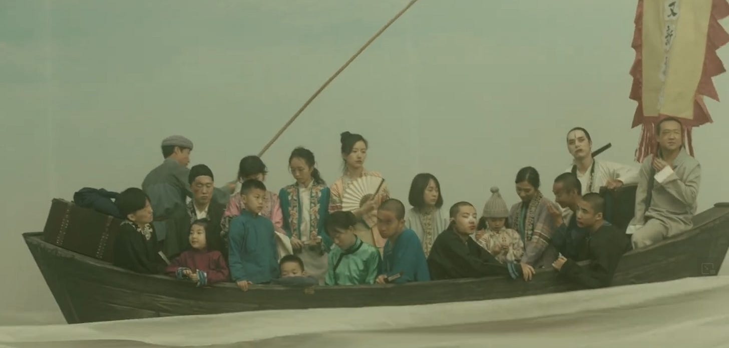 A group of people in historical Chinese clothing on a fake boat