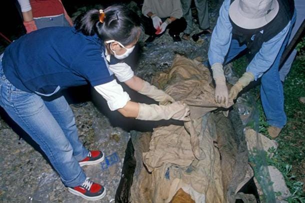 Archaeologists in Andong City, South Korea, unwrap cloth covering the 16th-century mummy of Eung-tae, a member of Korea's ancient Goseong Yi clan. 