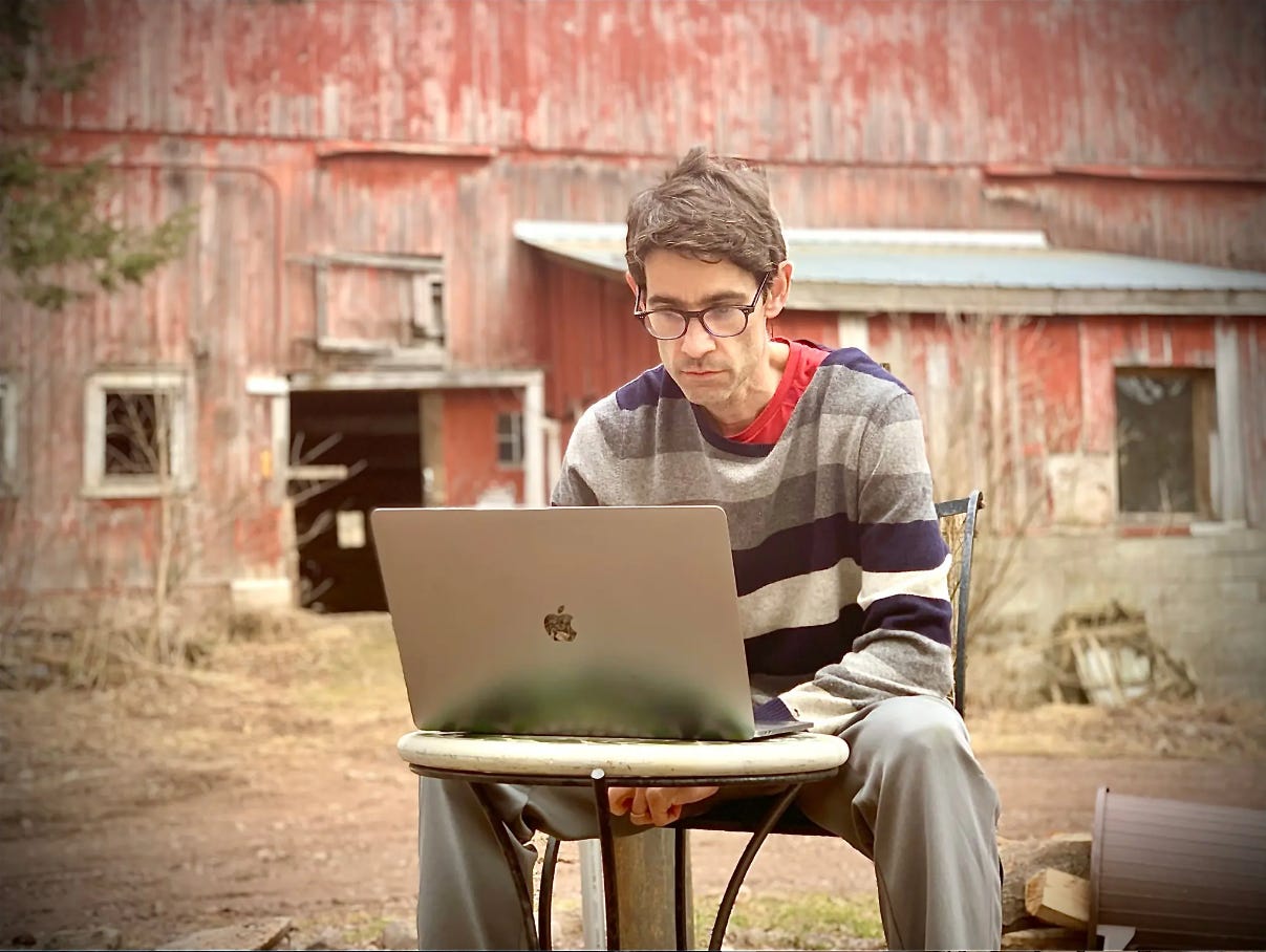 Nick Thompson on laptop outdoors