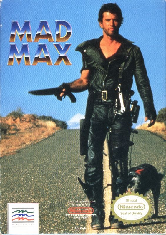 A scan of the front cover of the NES game, Mad Max, featuring Mel Gibson and his dog companion, taken from The Road Warrior. They're walking down the road, shotgun in hand, with the game's logo in the top left hanging in the blue sky.