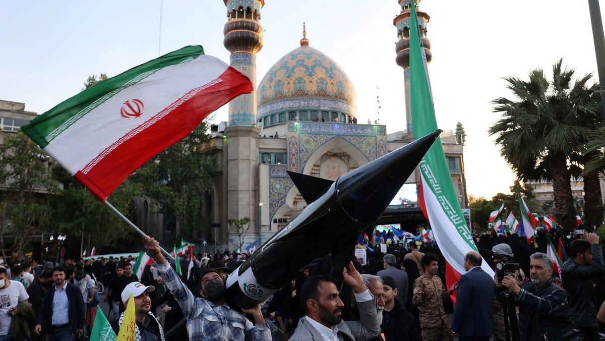 Iranians carry a model of a missile during a celebration following the IRGC attack on Israel, in Tehran, on April 15, 2024.