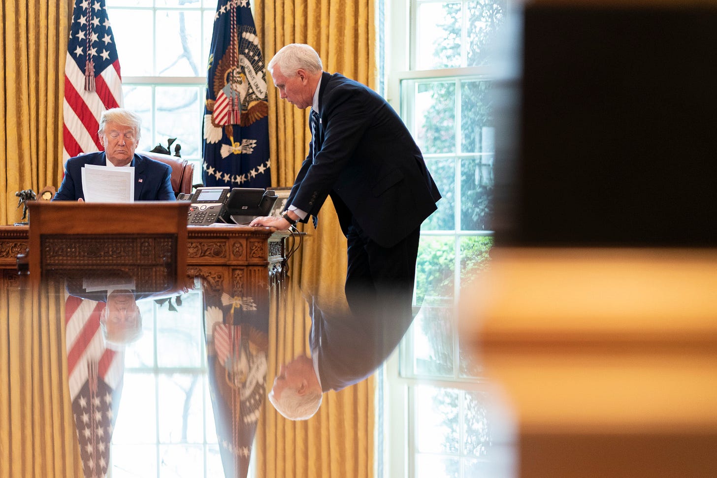 President Donald Trump and Vice President Mike Pence in the Oval Office reading papers. President Donald Trump and Vice President Mike Pence in the Oval Office reading papers.