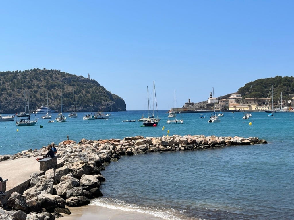 The Port of Soller's harbor, with moored sailboats and a cerulean blue sky.