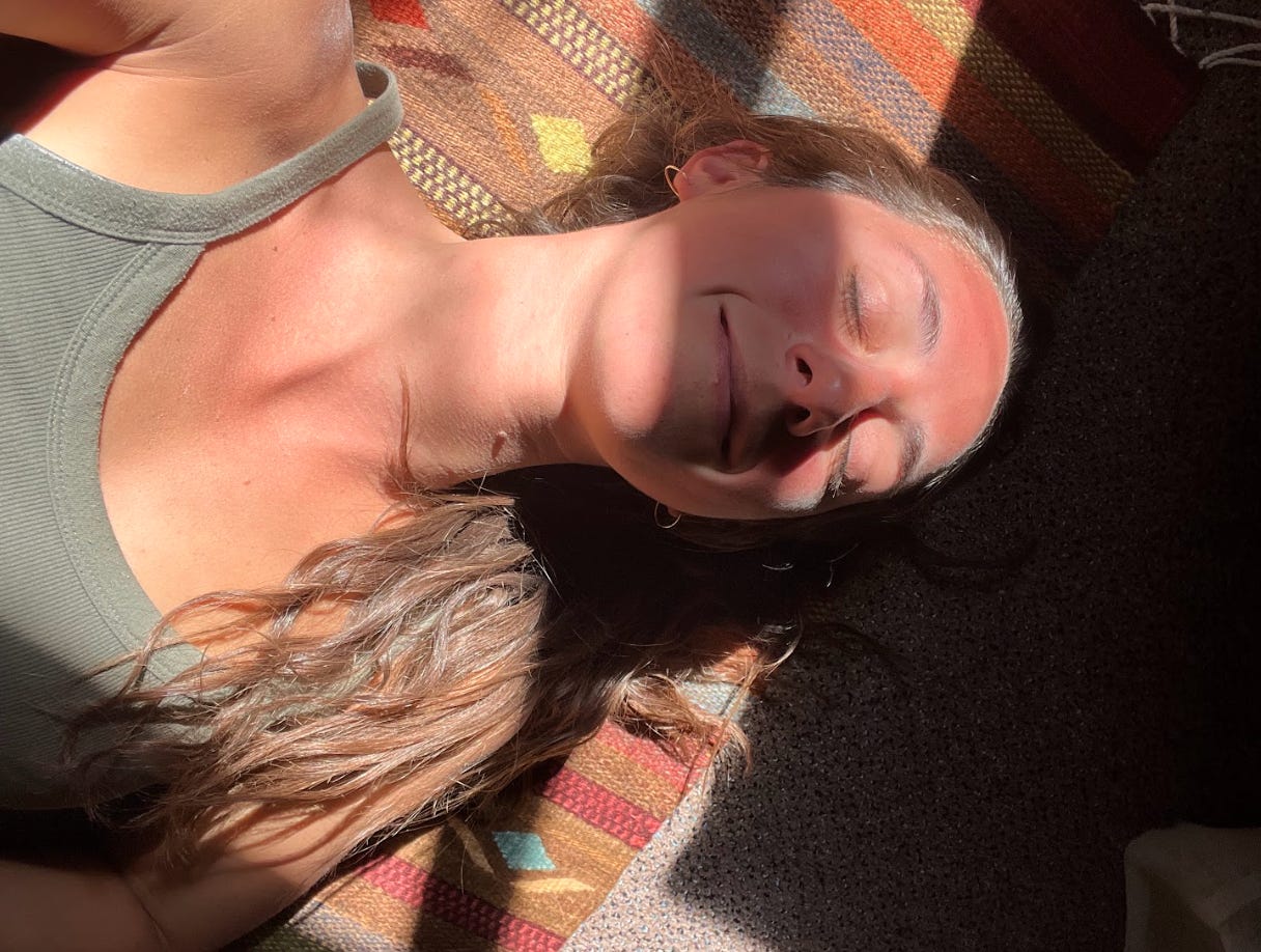 brunette woman lying on a rug in the sun