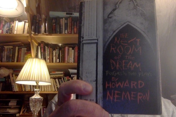 In a dimly-lit book-lined office, a hand holds to the camera a copy of "The  Next Room of the Dream. Poems and two plays by Howard Nemerov". The book cover image is a contains the lettering in a crude, graffiti-like style against a backdrop of a dark gothic archway in what appears to be a dilapidated church.