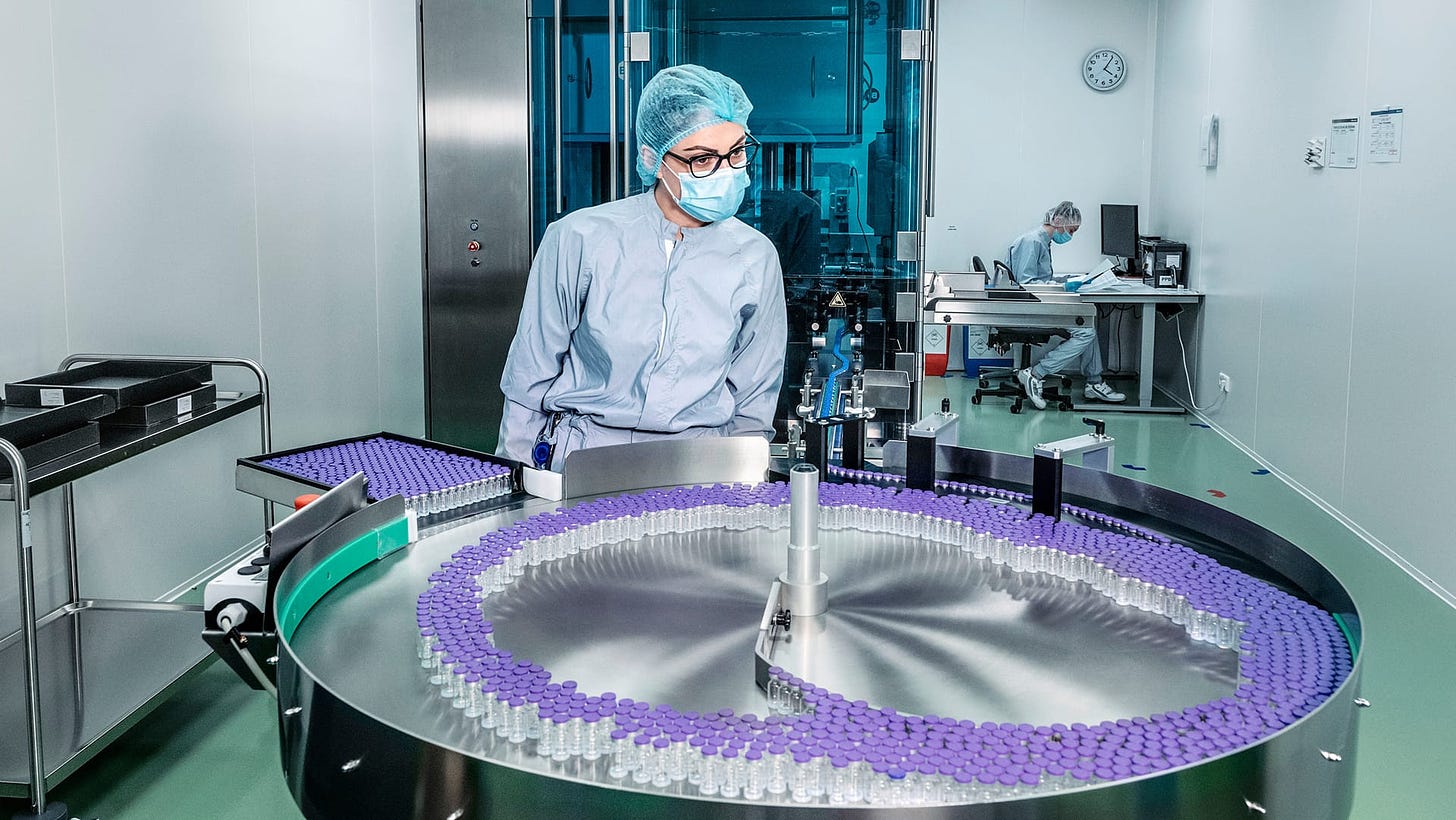 A lab worker supervises the assembly of a production batch with ready-filled vaccine ampoules