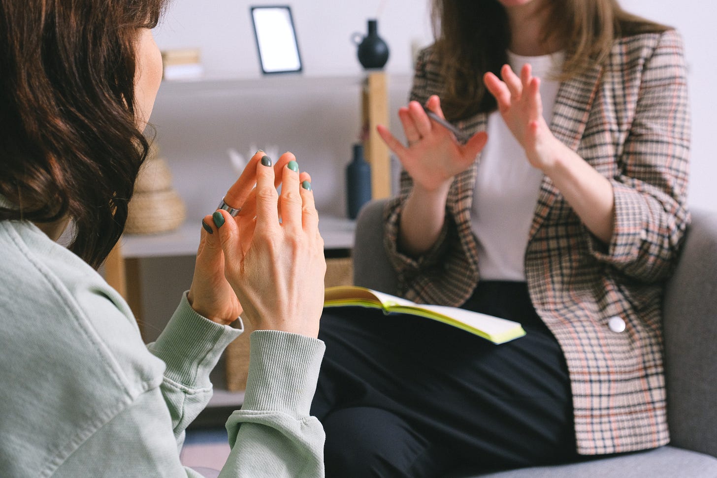 Two people arguing in a workplace setting they both have their hands up and you cannot see their faces