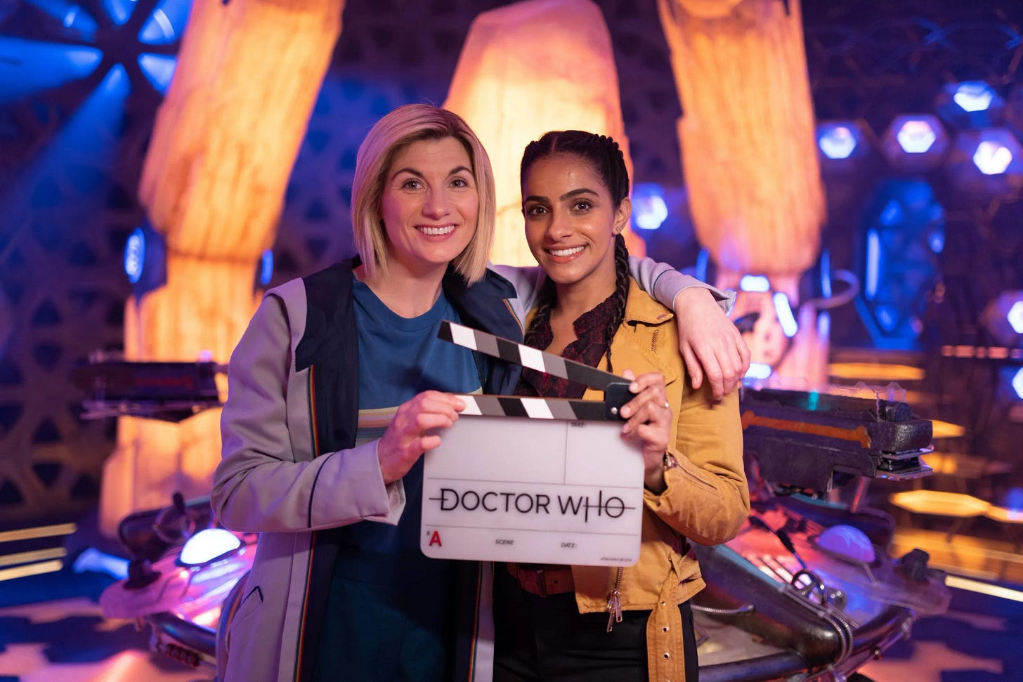 This image shows Jodie Whittaker (the Thirteenth Doctor, left) and Mandip Gill (Yasmin "Yaz" Khan, right) standing on the TARDIS set, holding a clapper-board, and smiling after finishing their final shots for "The Power of the Doctor." This image shows Jodie Whittaker (the Thirteenth Doctor, left) and Mandip Gill (Yasmin "Yaz" Khan, right) standing on the TARDIS set, holding a clapper-board, and smiling after finishing their final shots for "The Power of the Doctor."
