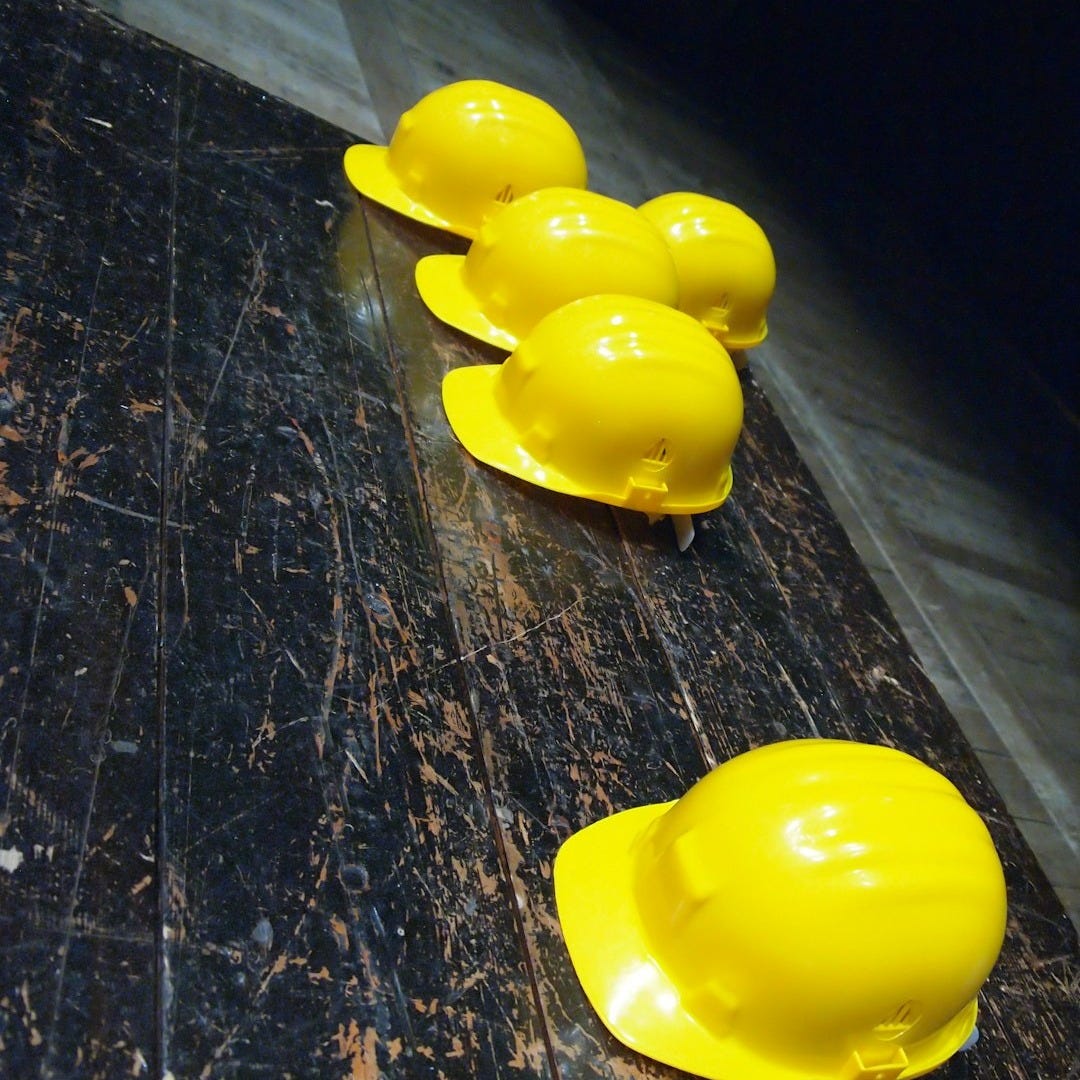 five yellow hard hats on gray surface five yellow hard hats on gray surface