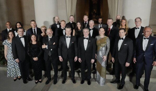 May be an image of 13 people, suit and the Oval Office