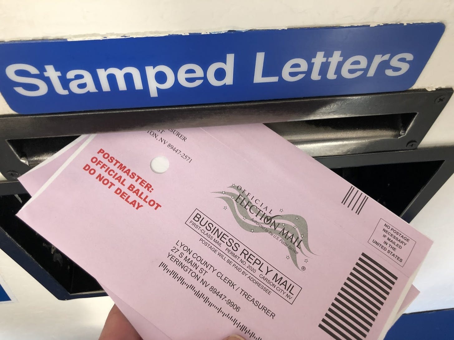 In this October 13, 2022 photo, a voter drops a completed ballot into a mailbox in Lyon County, Nevada.