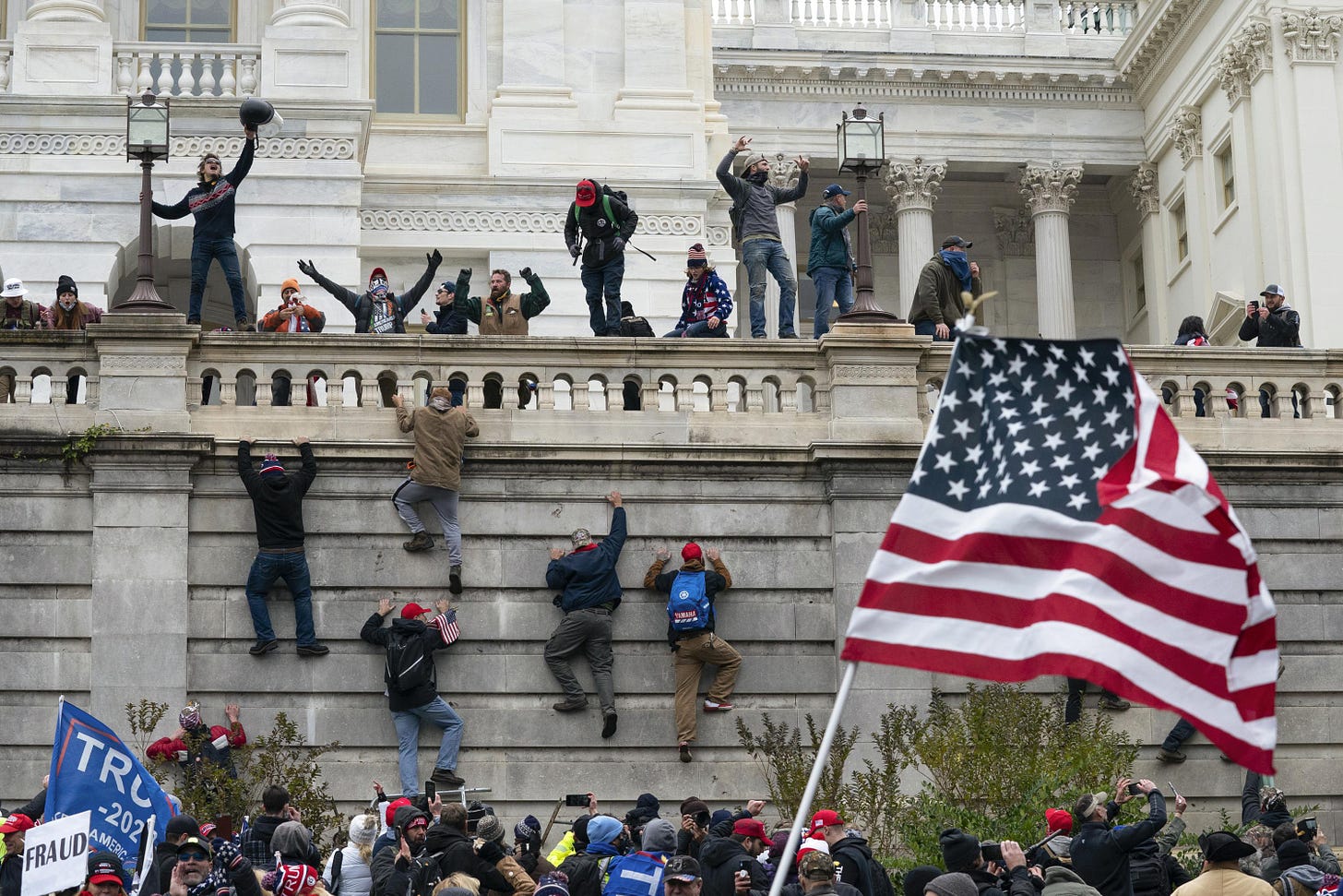 a picture of insurrectionists after they broke into the Capitol. They are celebrating 