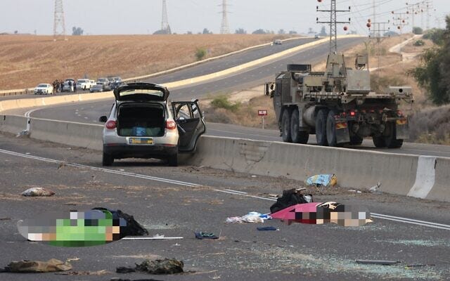 Bodies lie on a main road near Kibbutz Gevim on October 7, 2023 following an attack by Hamas terrorists. (Oren ZIV / AFP)