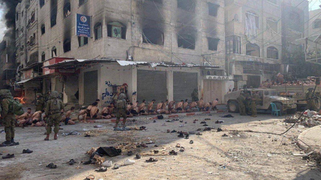Captured and detained Palestinians sit on a street in Beit Lahia Captured and detained Palestinians sit on a street in Beit Lahia