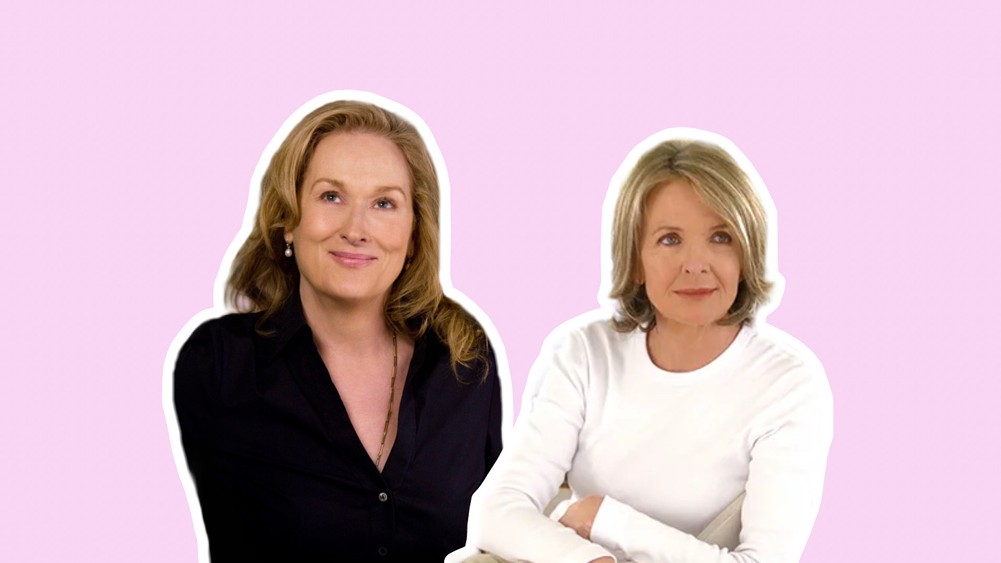 Against a solid pastel pink backdrop, Meryl Streep, wearing a black blouse with her (blonde) hair down, sits to the left of Diane Keaton, who has a greying blonde bob and her arms crossed in a white sweater.