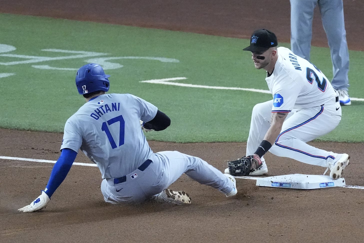 Shohei Ohtani (17) of the Los Angeles Dodgers steals his 50th base of the season as Miami Marlins third baseman Connor Corby tries to tag him in the Dodgers versus Marlins contest on September 19, 2024 (Photo: Associated Press/Wilfredo Lee).