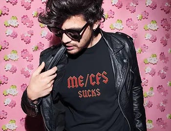Pink flower wallpaper/ In front a man with black hair and shades wearing a black leather jacket and ME/CFS sucks t shirt. 