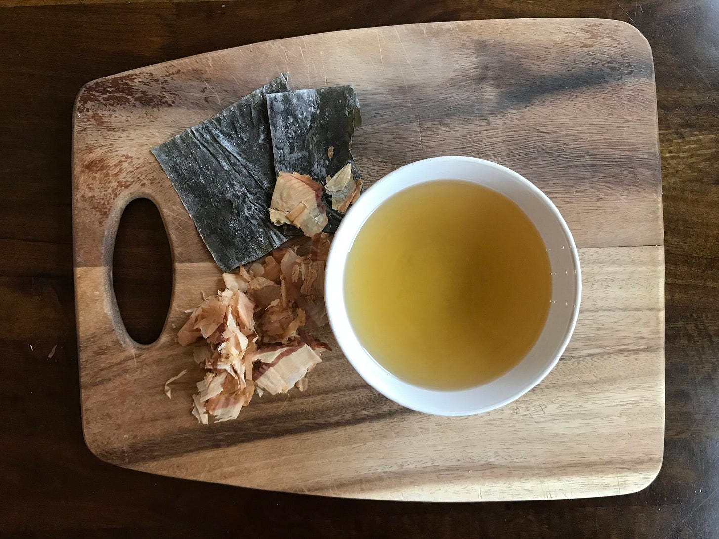 Kombu (upper left), katsuobushi (lower left) and water combine to make dashi (right).