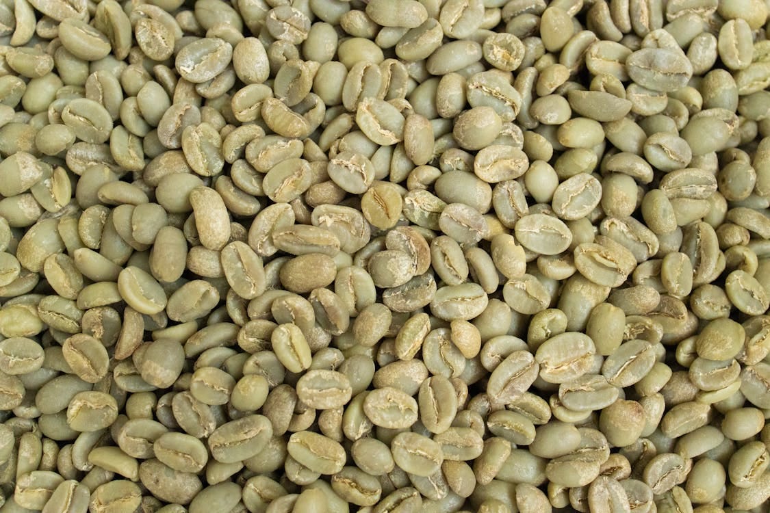 Free Detailed close-up of fresh, raw green coffee beans, ideal for roasting. Stock Photo