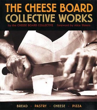 Image of the cover of a cookbook, titled "The Cheese Board Collective Works", by the Cheese Board Collective. Image underneath title is focused on a person's hands, cutting a piece of cheese with a large knife.