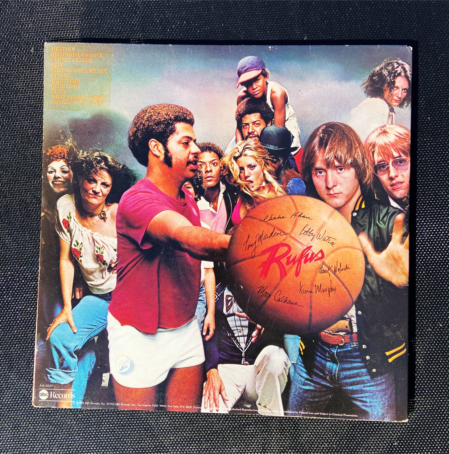 the back cover for my vinyl of Rufus & Chaka Khan's 1978 album Street Player. it features the band front and center, with a cast of characters looming playfully in the background.