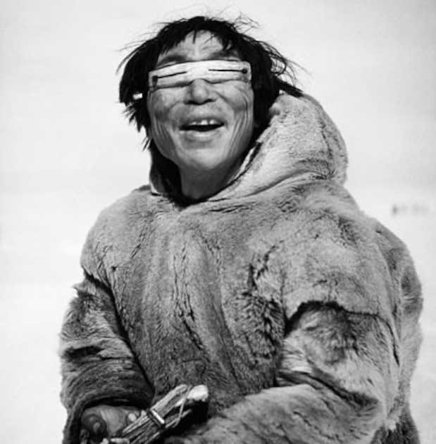 Photograph by Archibald Fleming of an Inuit man wearing wooden snow goggles with slits for eye protection. (Public domain)
