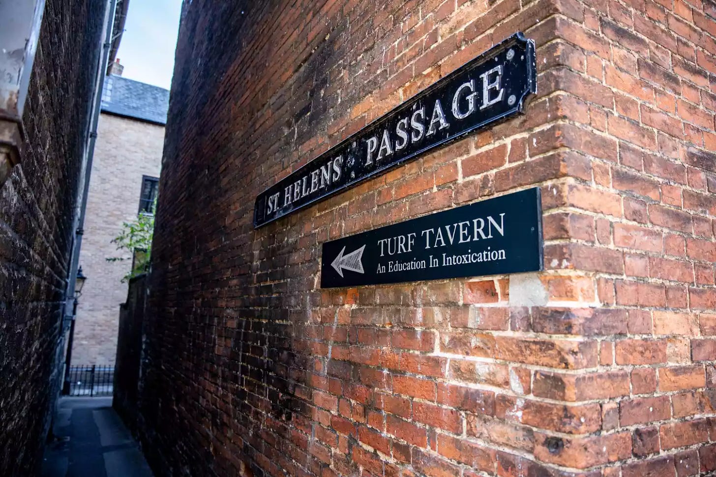 A sign pointing down an alley for Turf Tavern