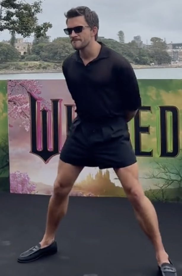 Jonathan Bailey on the Wicked Press Tour in Australia wearing those short shorts that everyone wernt bonkers about, legs splayed very wide