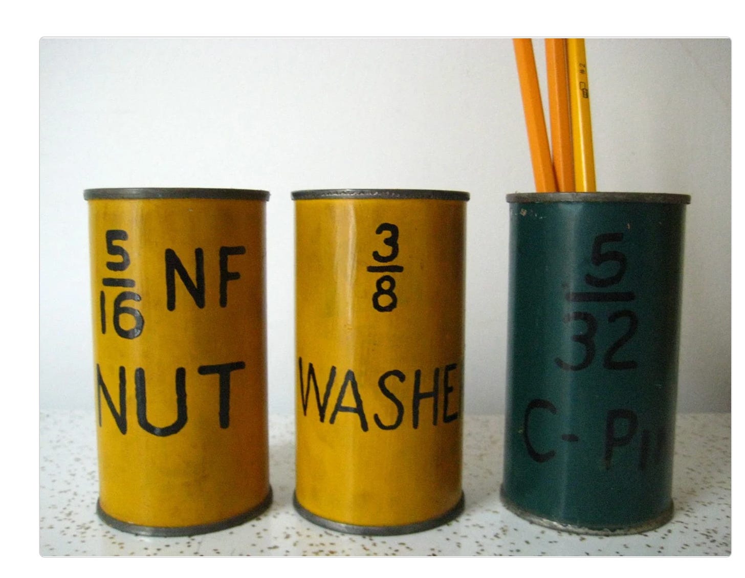 photo of two yellow and one teal juice can that are hand painted with the numbers 5/16 NF NUT, 3/8 WASHERS and 5/32 C-PIN, with yellow pencils coming out of the teal can. caption explains this is an etsy listing photo