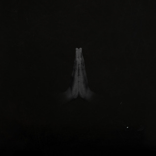 A black cover with a photograph of two black hands praying