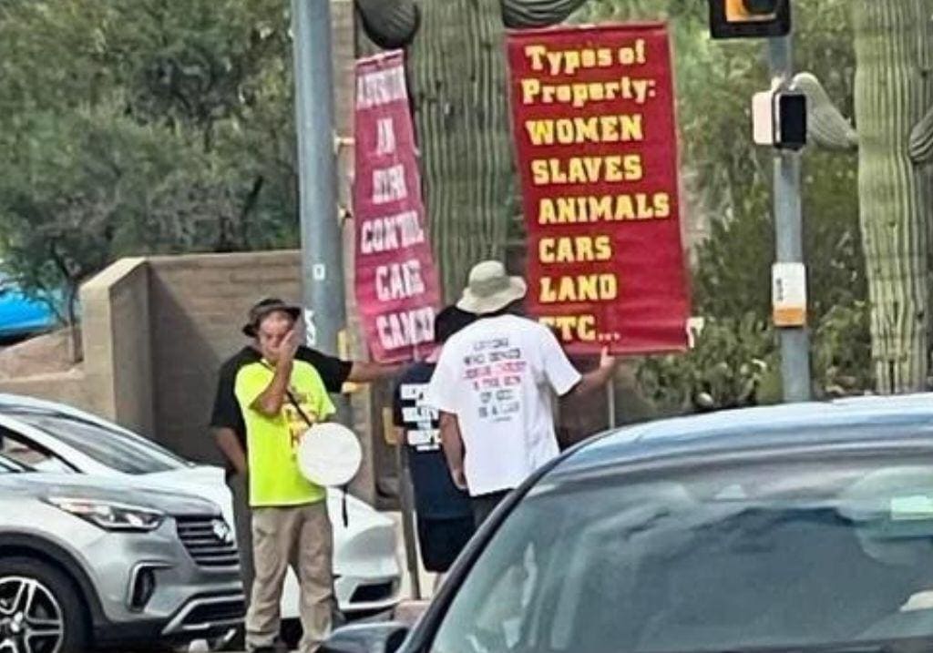 christian abortion protestors holding sign that says "types of property: women slaves animals cars land etc"