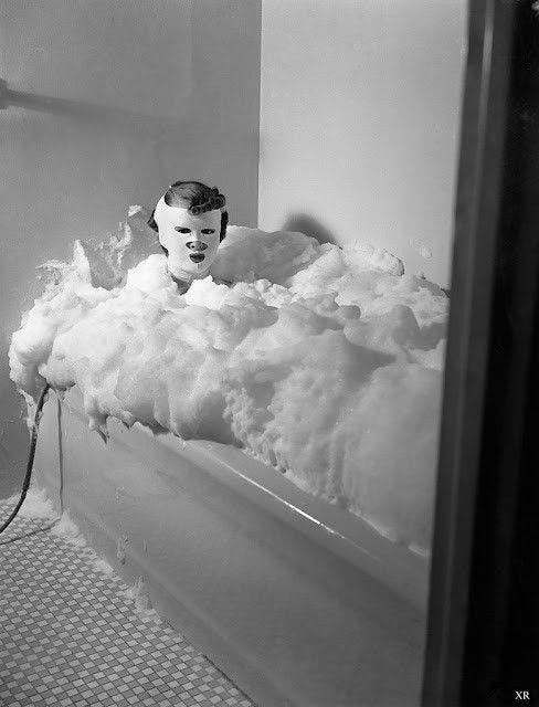 This may contain: a woman in a bathtub covered with foam