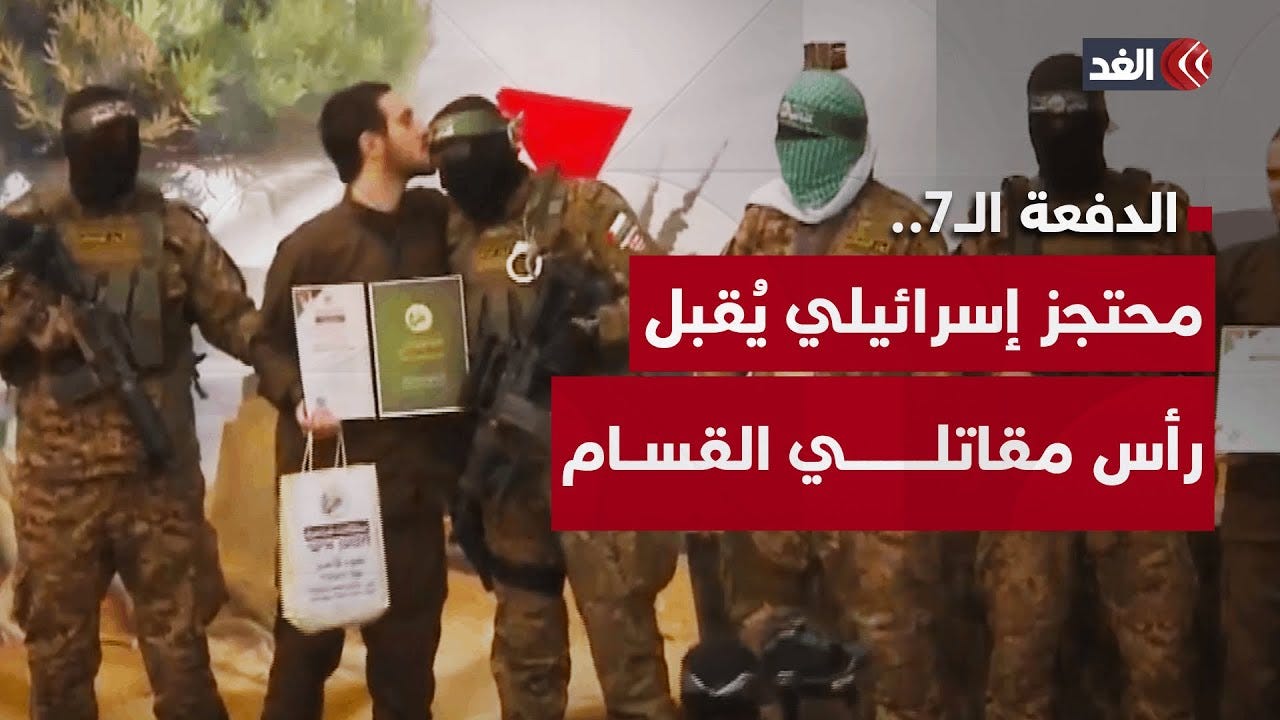 مشهد يحدث لأول مرة.. محتجز إسرائيلي يُقبل رأس مقاتلين بالقسام على منصة  التسليم في النصيرات