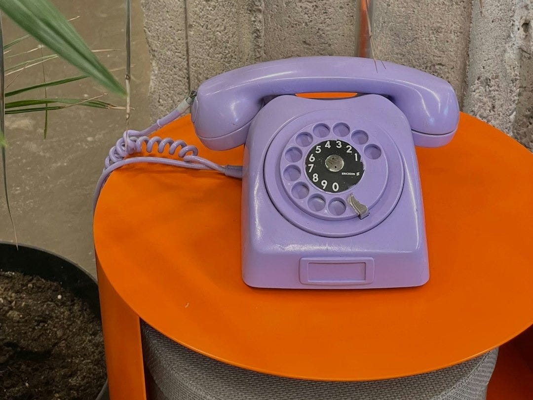 a purple phone sitting on top of an orange table a purple phone sitting on top of an orange table