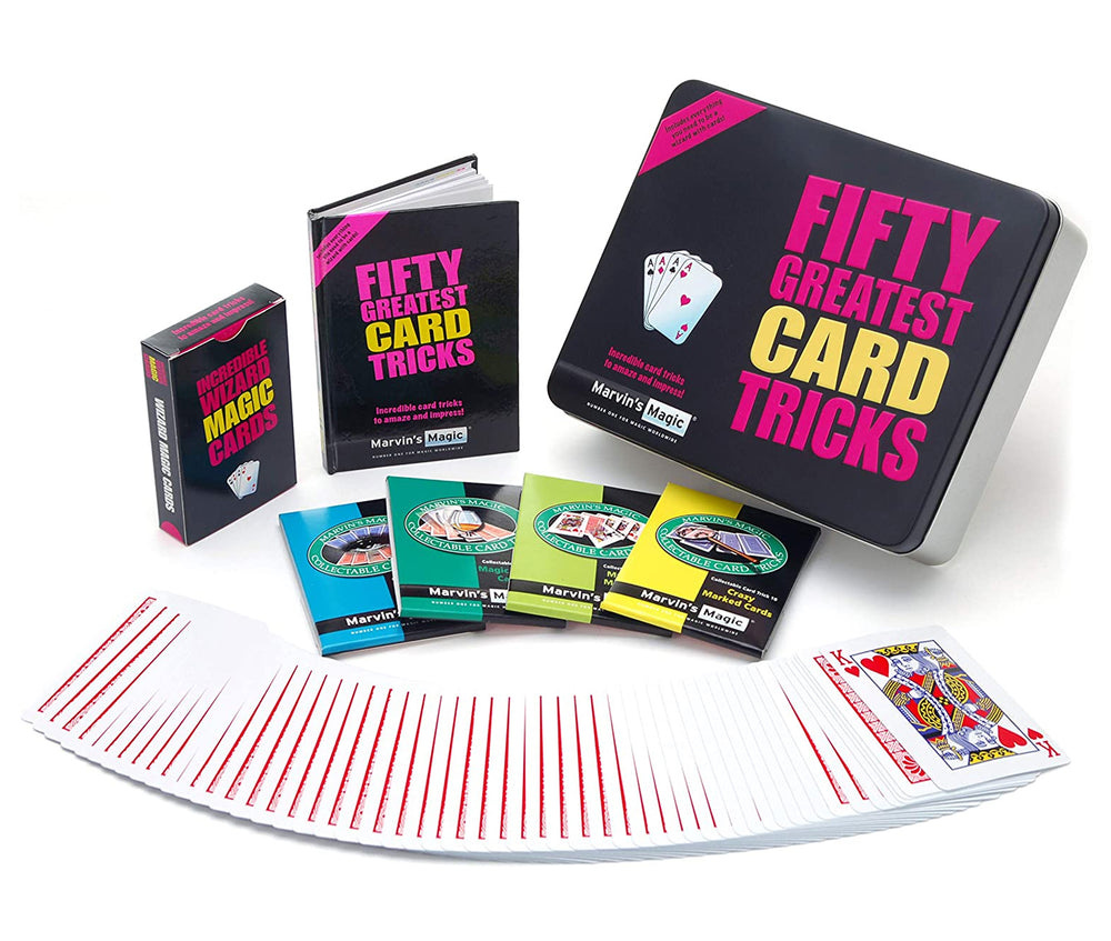 A photograph of a magic kit in a mental tin. Next to the tin is a small book, a deck of "Incredible Wizard Magic Cards", four packet tricks in cardboard sleeves, and a deck of cards spread across the table, with the King of Hearts face up on top.
